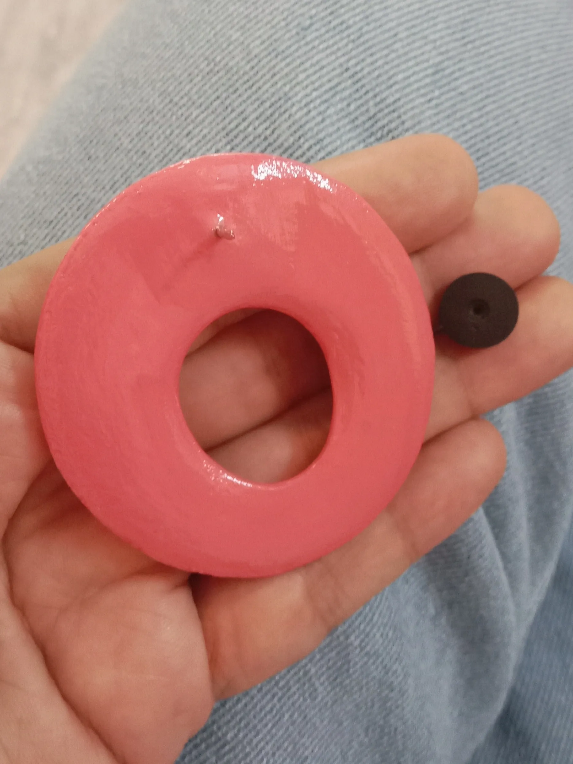 Close up of the back of hand-painted olive green leaf motif and high-gloss oval pink clay eyeglass holding pin.