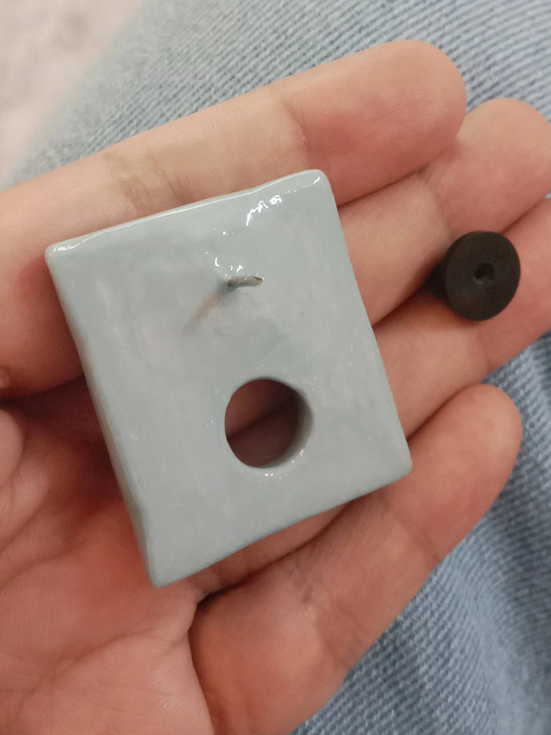 Back of a clay brooch featuring anti tarnish pin and a secure rubber backing