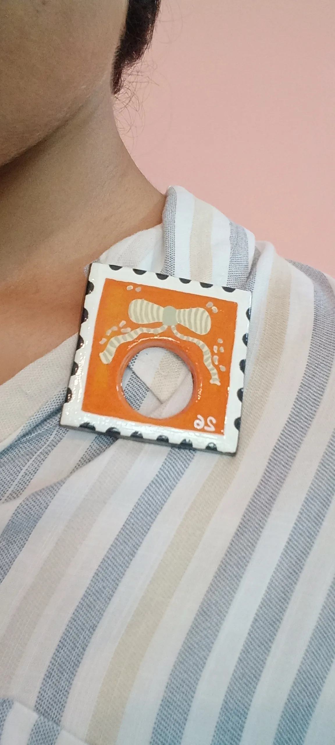 Clay brooch pinned on the collar of a shirt